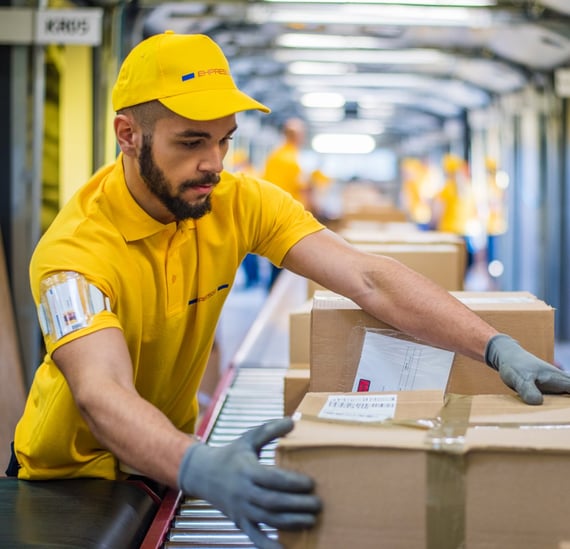 Shipper guiding labeled package along warehouse conveyor line